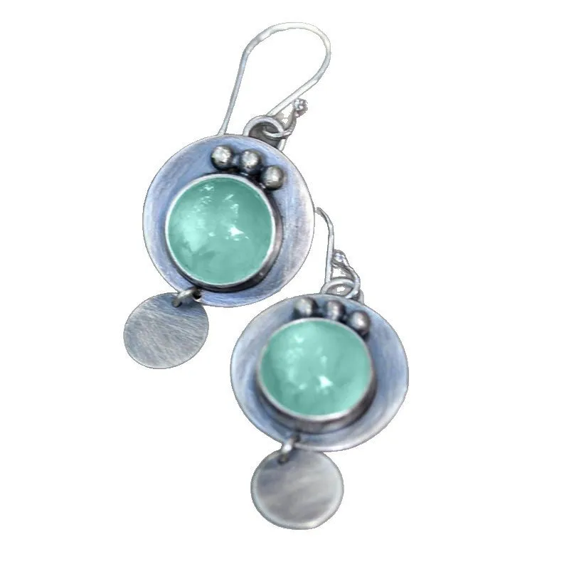 Silver geometric round mint turquoise earrings for women on simple background.