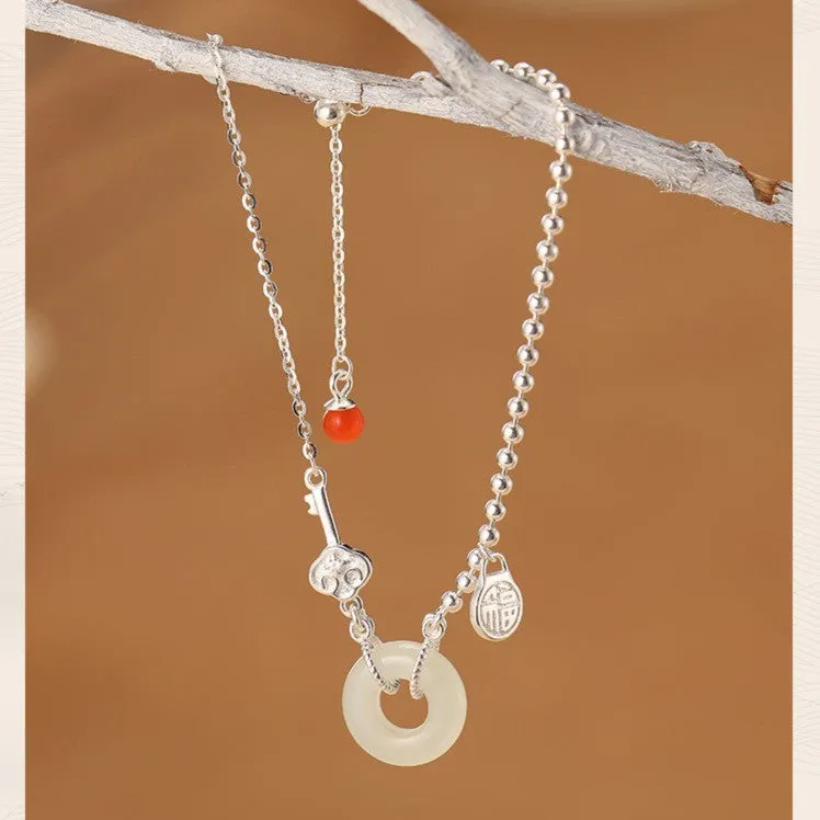 Women's Chinese style silver bracelet with a Hetian jade stone and intricate Peace Buckle design.