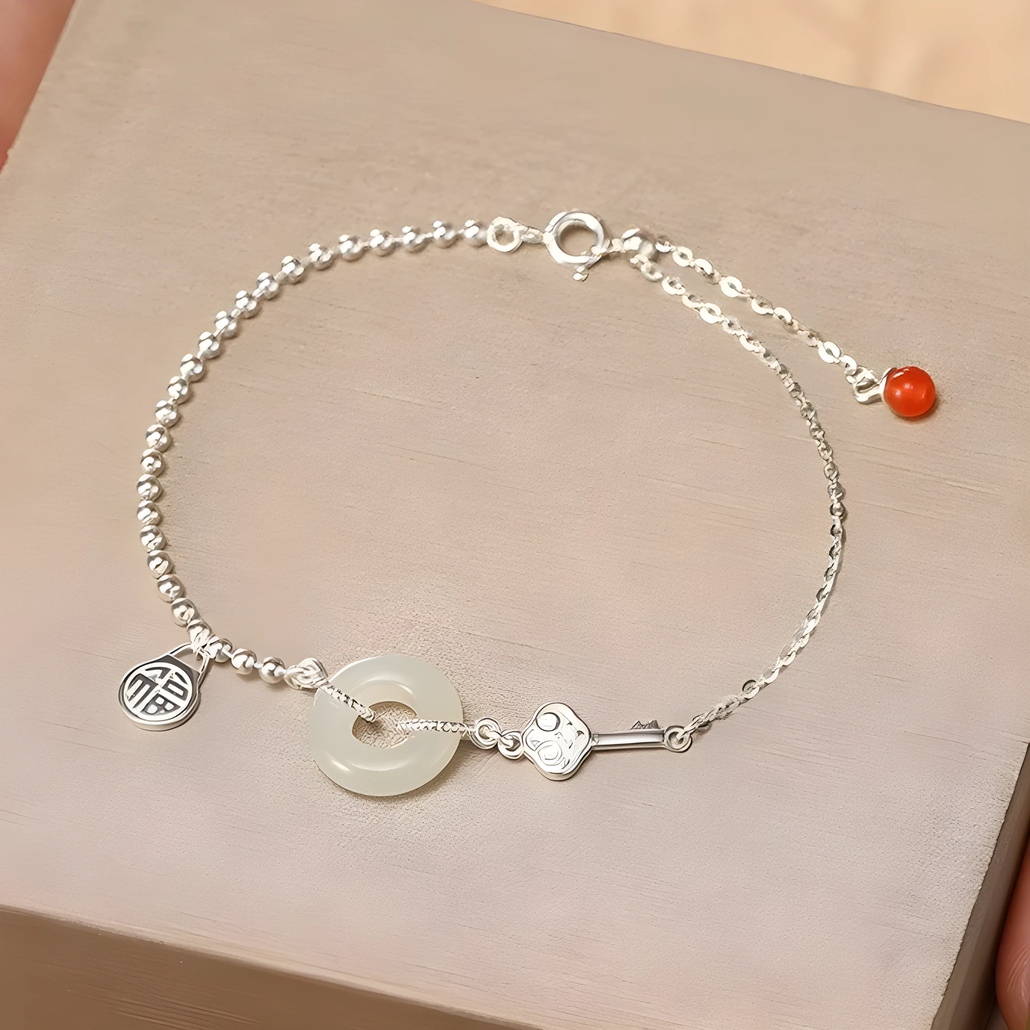 Women's Chinese style silver bracelet with a Hetian jade stone and intricate Peace Buckle design.