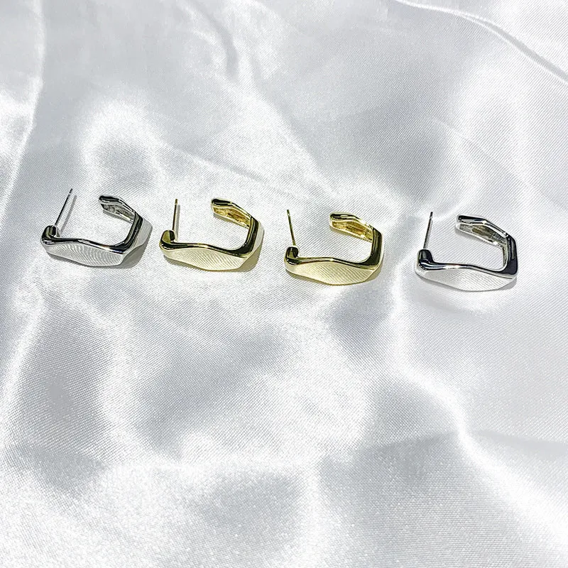 Irregular C-shaped metal stud earrings in Gold finish, minimalist design for everyday wear.