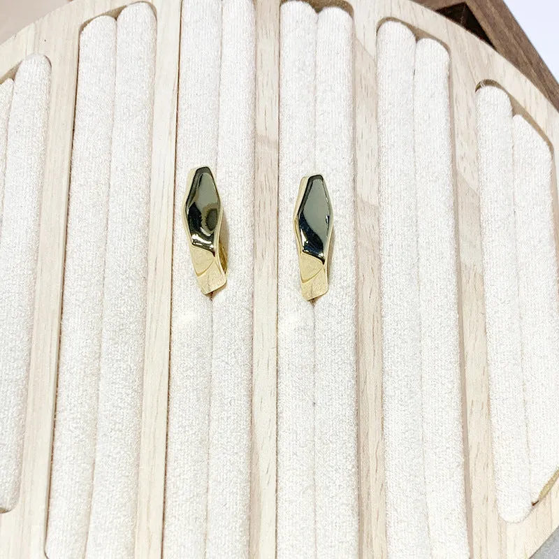 Irregular C-shaped metal stud earrings in Gold finish, minimalist design for everyday wear.