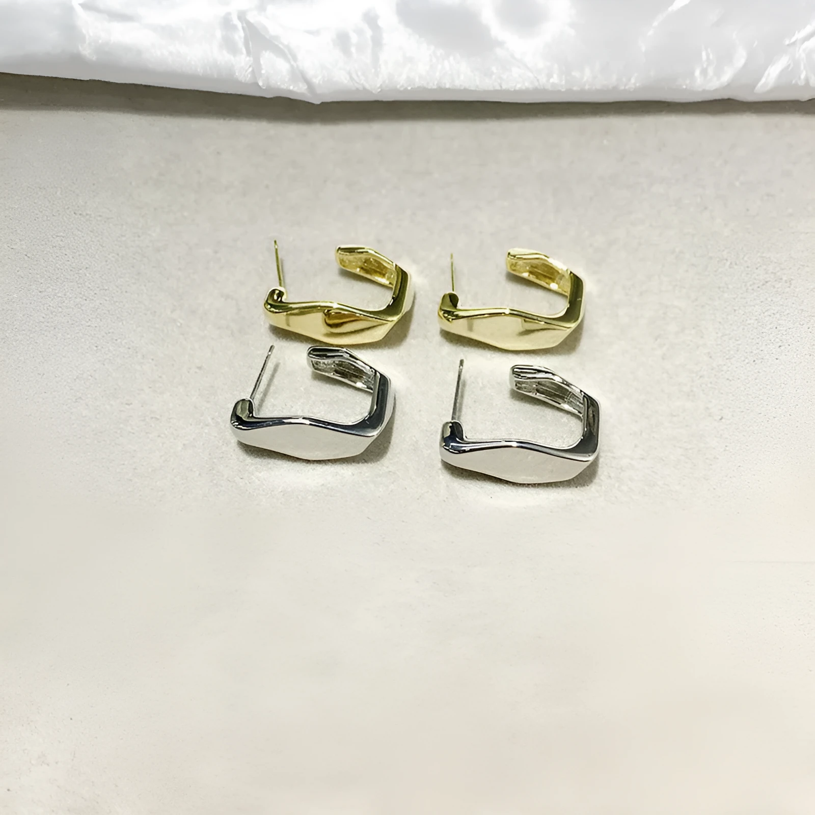 Irregular C-shaped metal stud earrings in Gold finish, minimalist design for everyday wear.