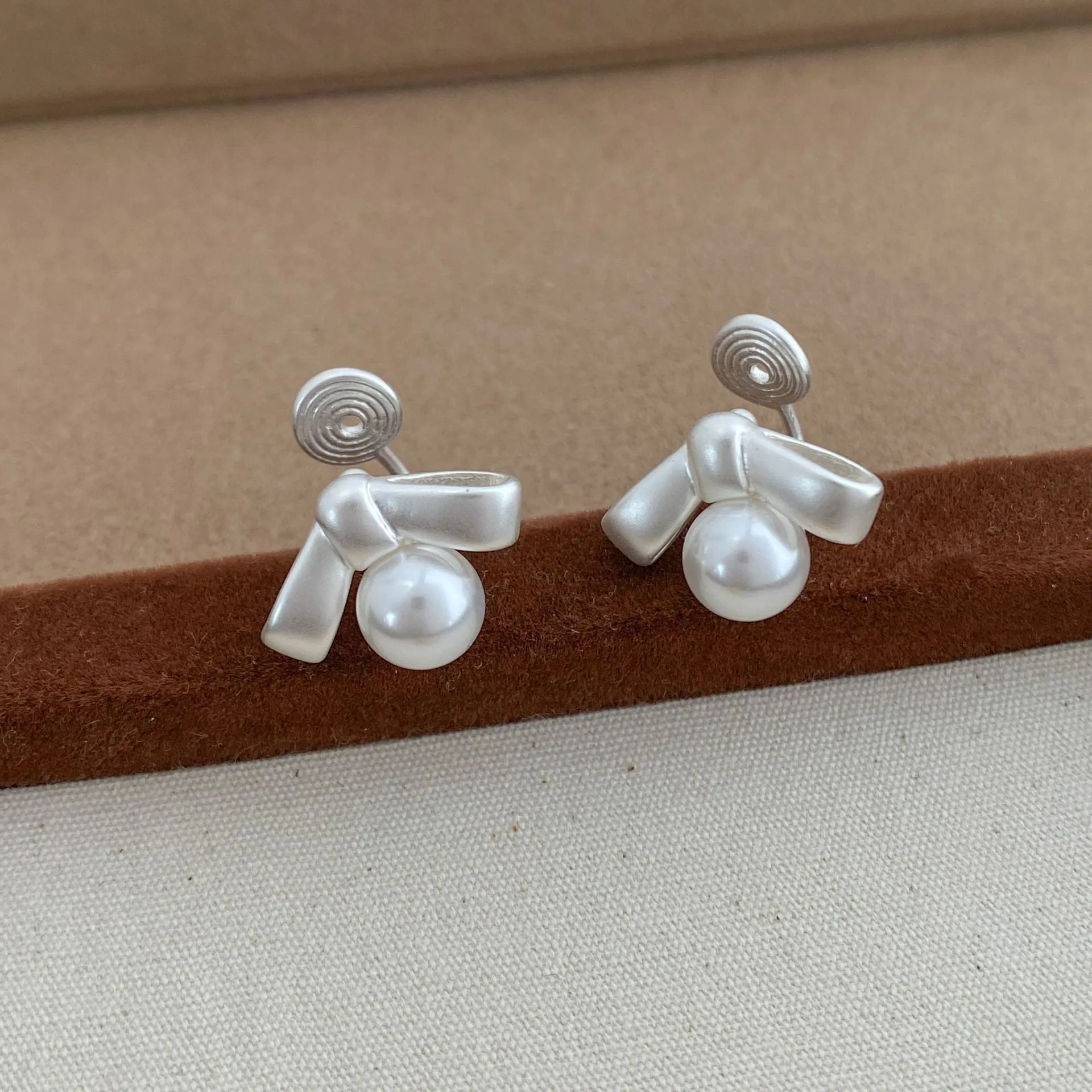 Matte bow earrings for women in matte gold clip-on style on a white background