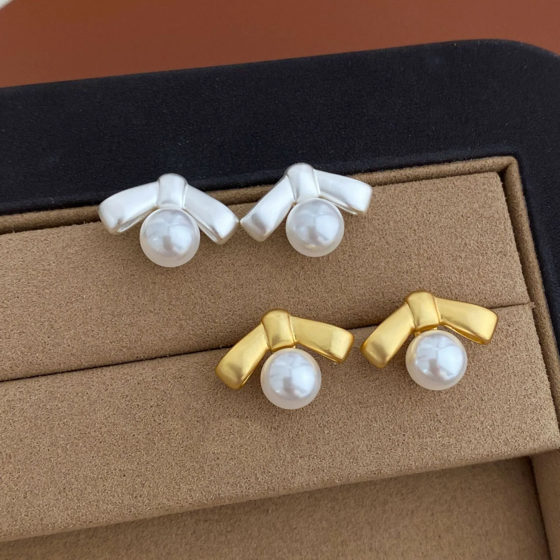Matte bow earrings for women in matte gold clip-on style on a white background