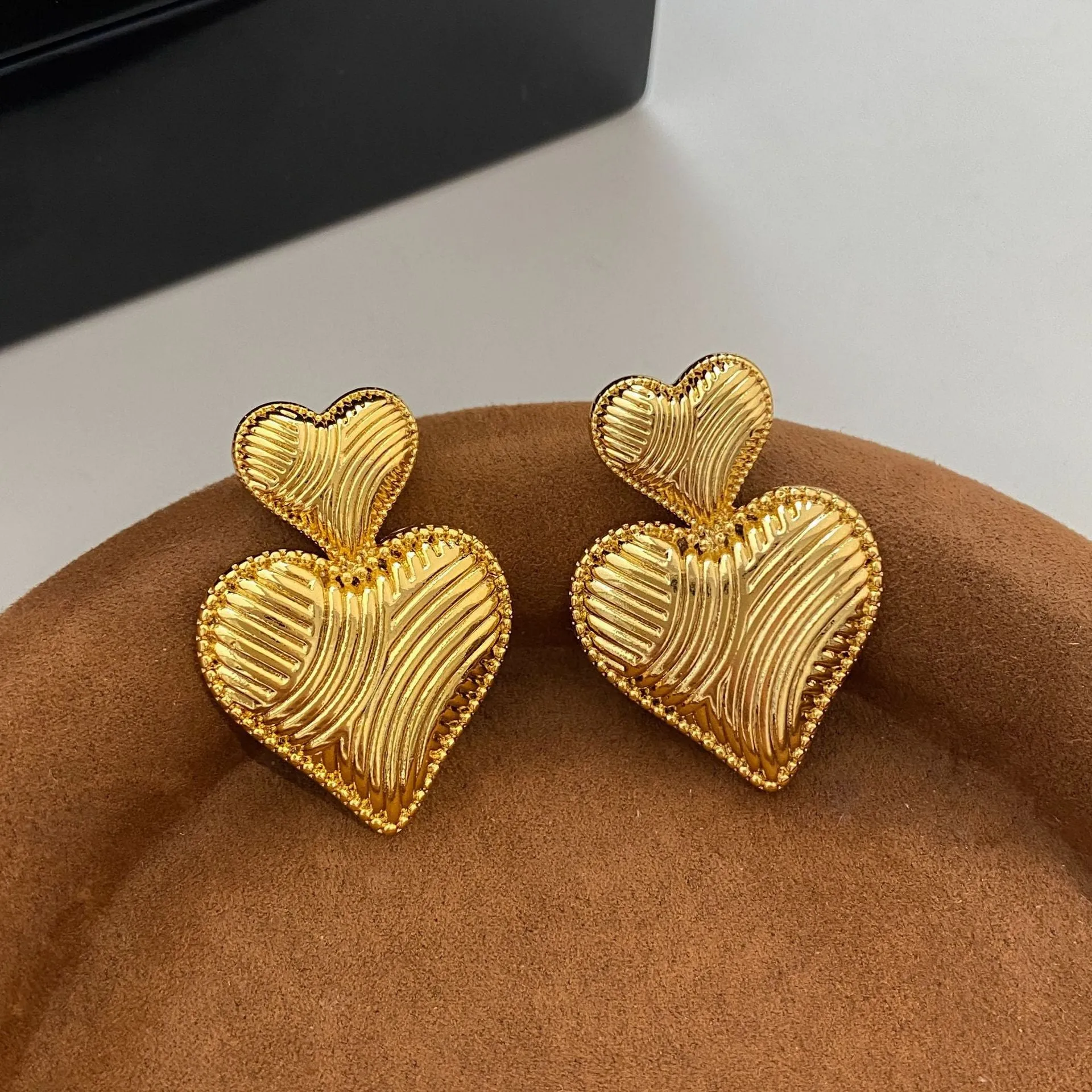 Double heart copper earrings with electroplated finish, available as ear clips or ear studs