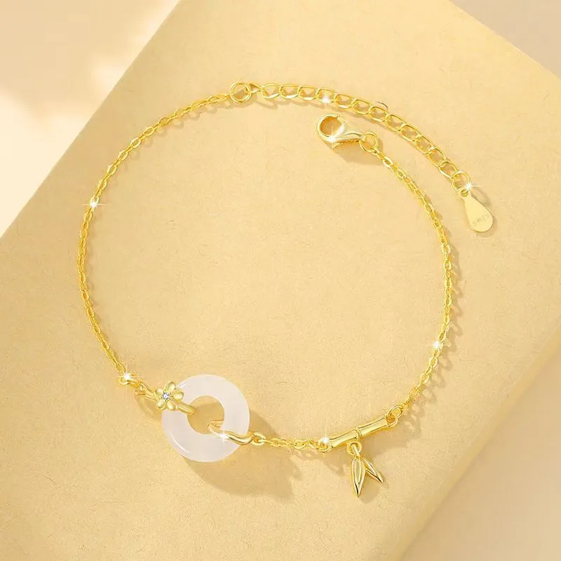 Gold tone women's bracelet with white chalcedony stone and adjustable peace symbol buckle closure