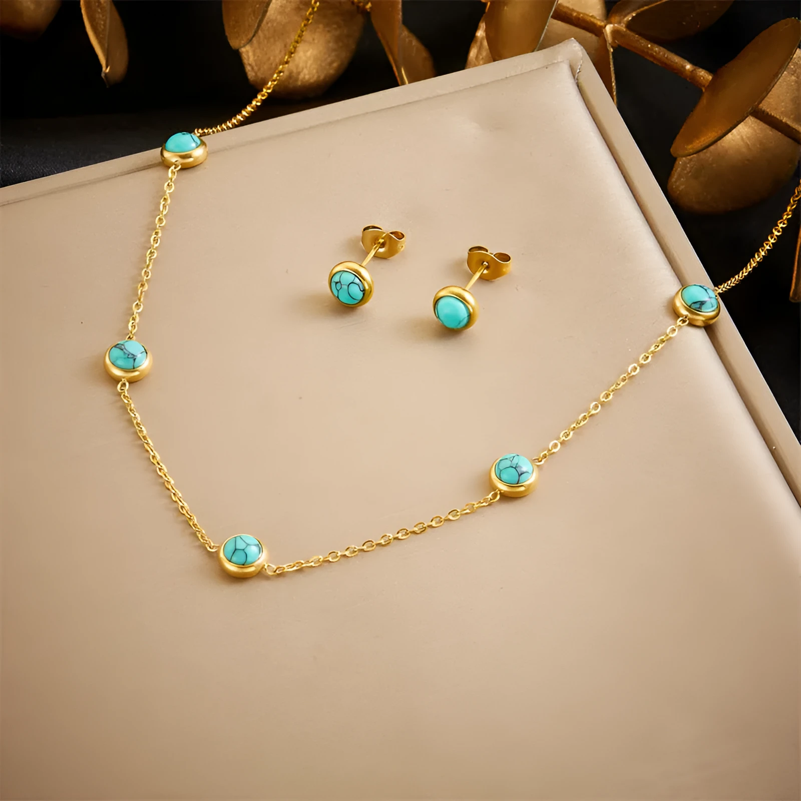 Round turquoise stainless steel earrings and necklace set on display