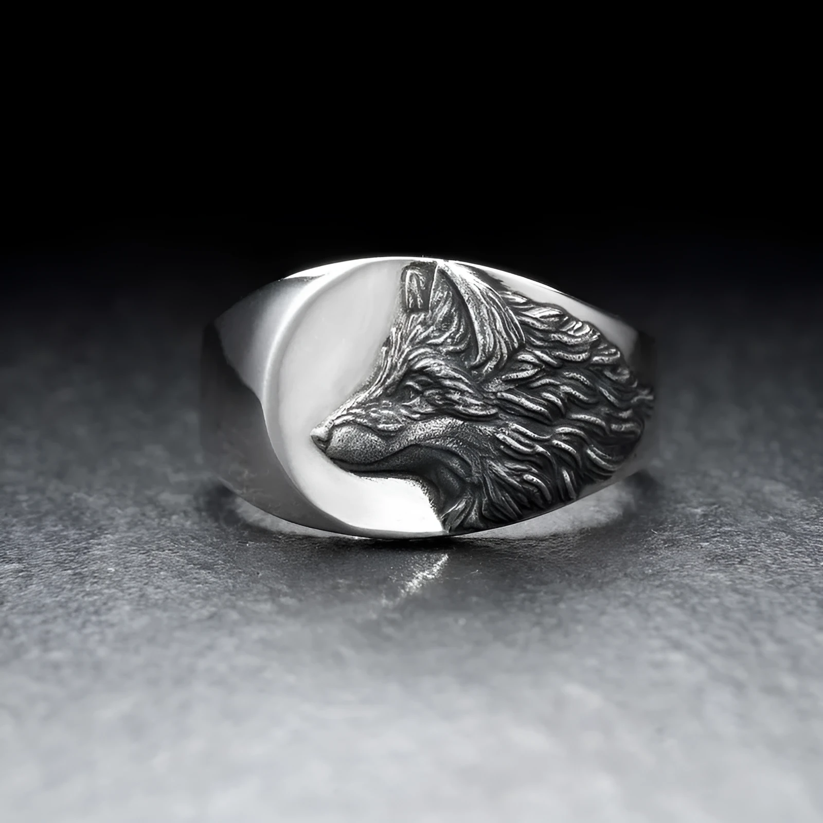 Silver men's ring with a geometric wolf design on a black background.