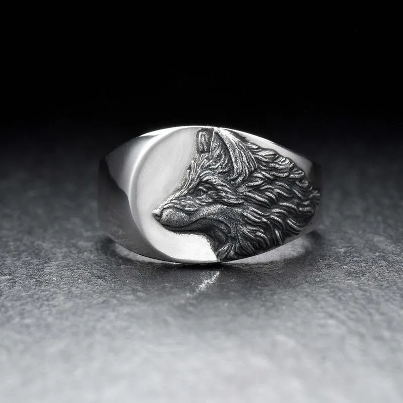 Silver men's ring with a geometric wolf design on a black background.