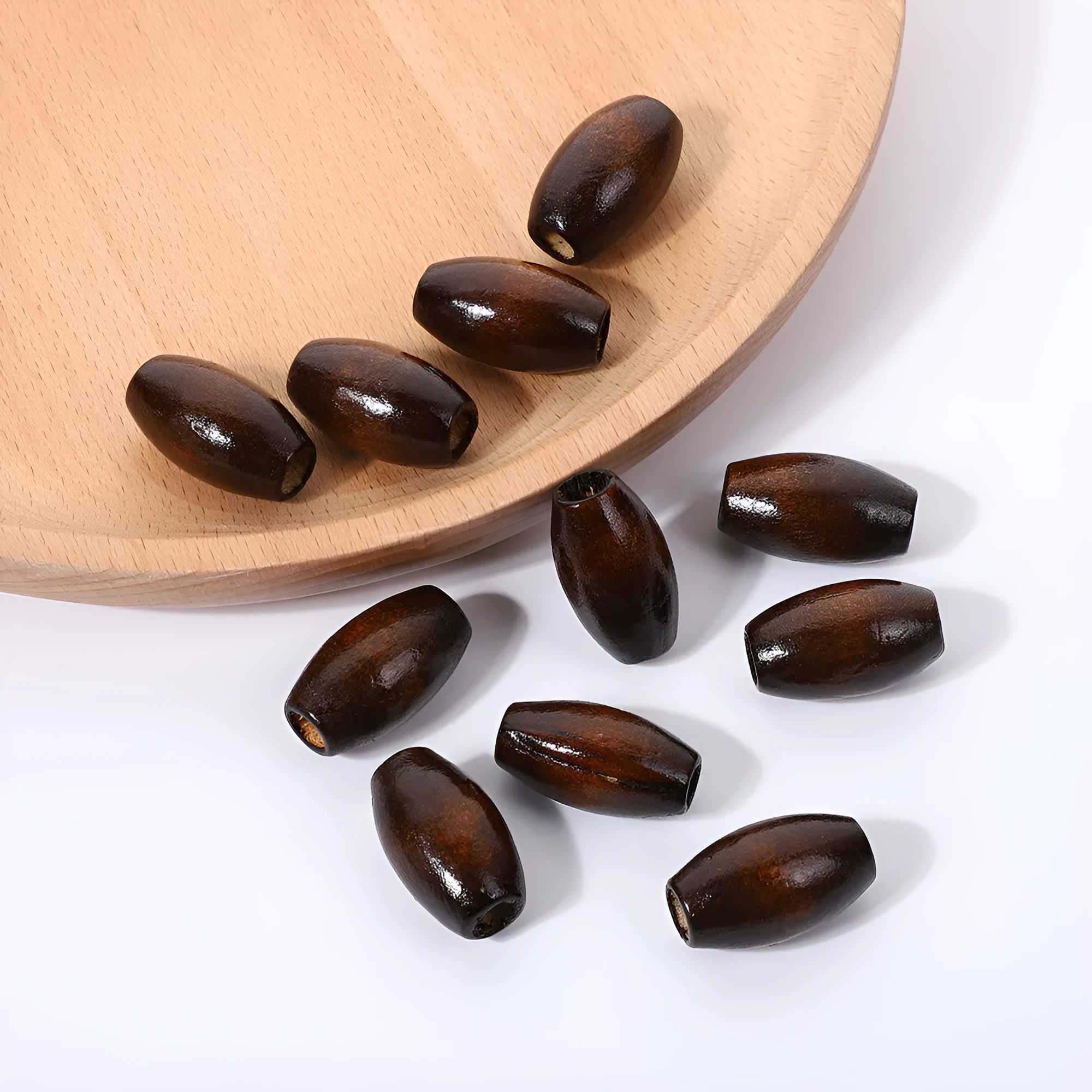 Dark coffee coloured wooden oval bead with M-shaped raised design, 25mm size