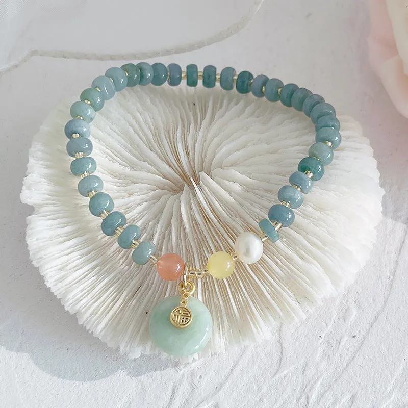 Natural blue water jade bracelet with gourd charm and peace buckle on woman's wrist