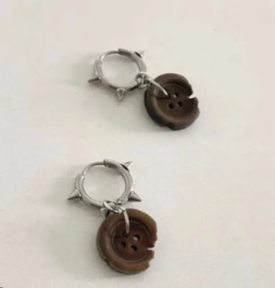 One pair of brown alloy ancient style burned gap button distressed earrings on neutral background