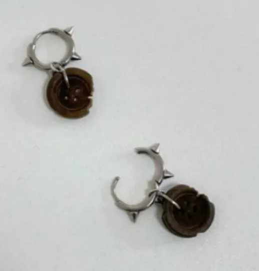 One pair of brown alloy ancient style burned gap button distressed earrings on neutral background