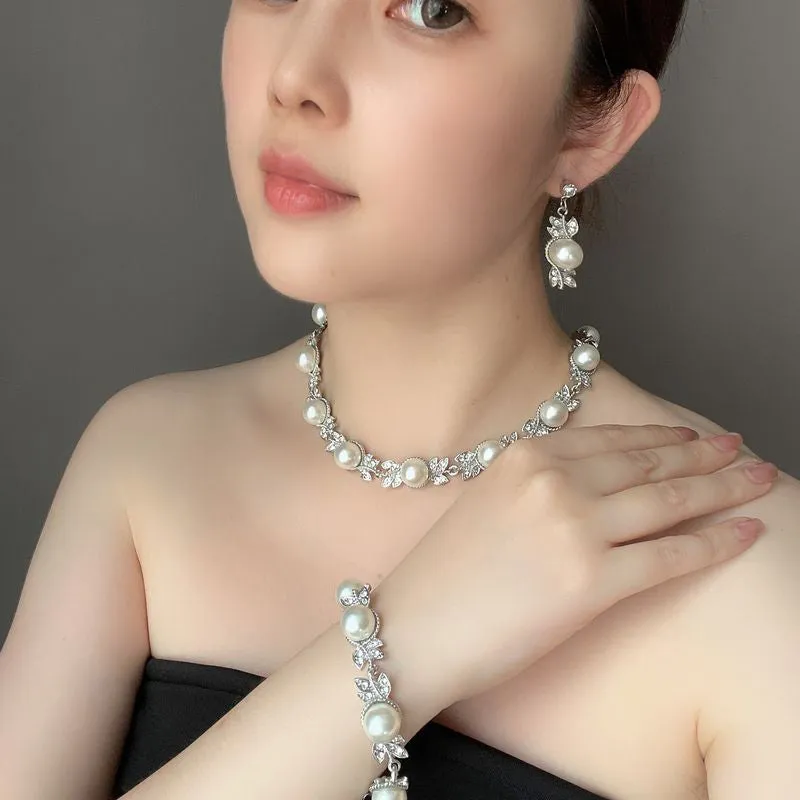 Three-piece jewellery set with rhinestone and pearl necklace, earrings, and bracelet in silver finish
