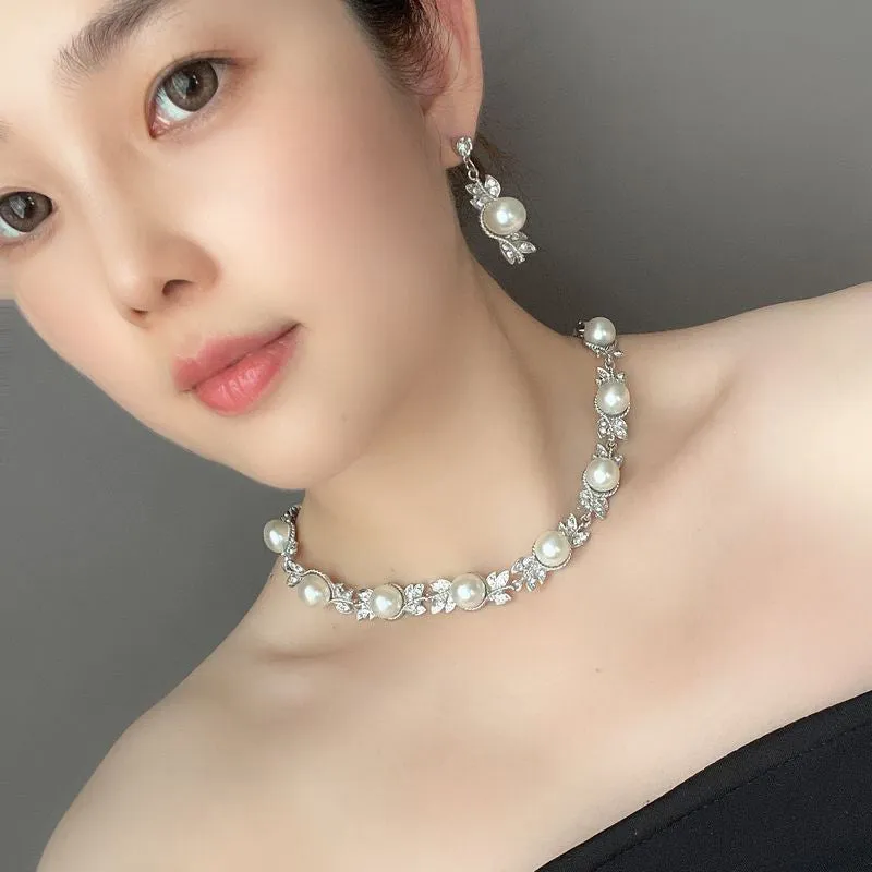 Three-piece jewellery set with rhinestone and pearl necklace, earrings, and bracelet in silver finish