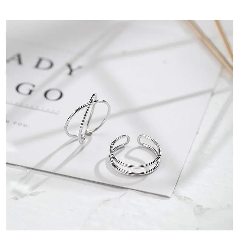 Silver geometric cross ring with adjustable opening on female hand