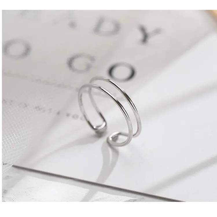 Silver geometric cross ring with adjustable opening on female hand