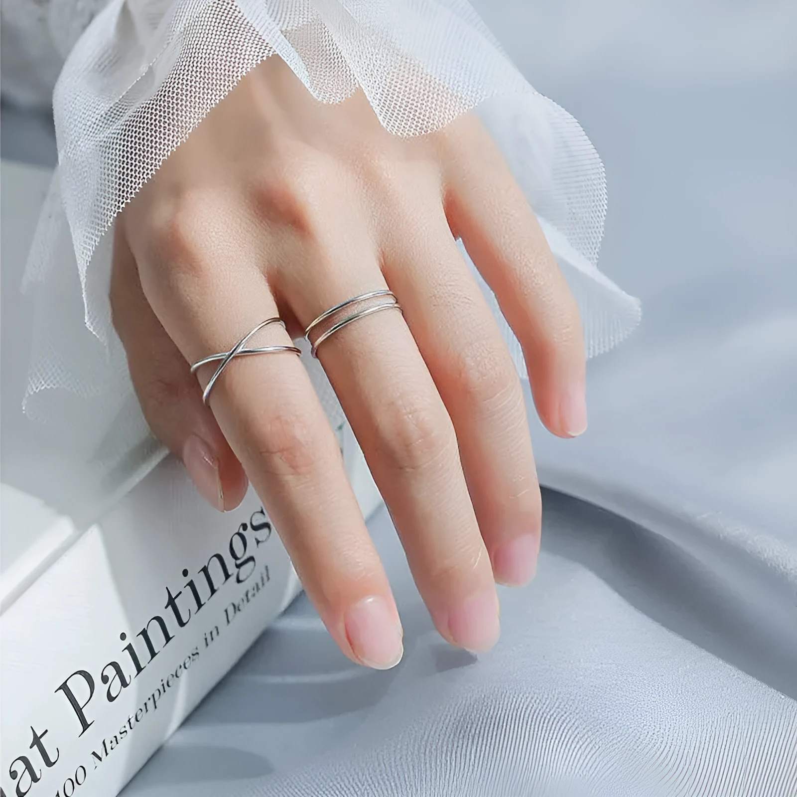Silver geometric cross ring with adjustable opening on female hand