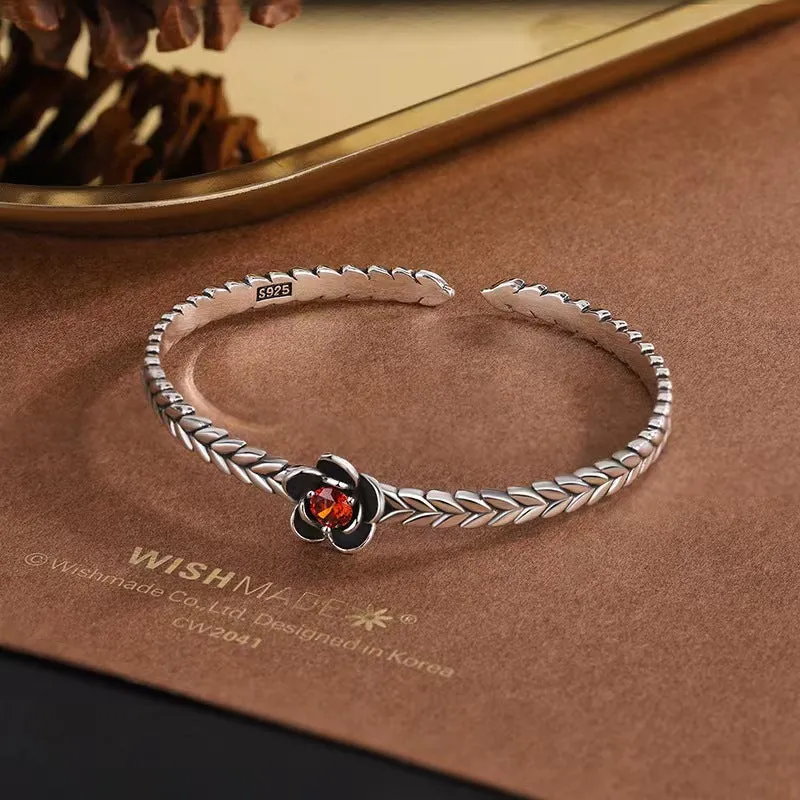 Silver zinc alloy retro bracelet with red zirconium plum flower centrepiece on white background