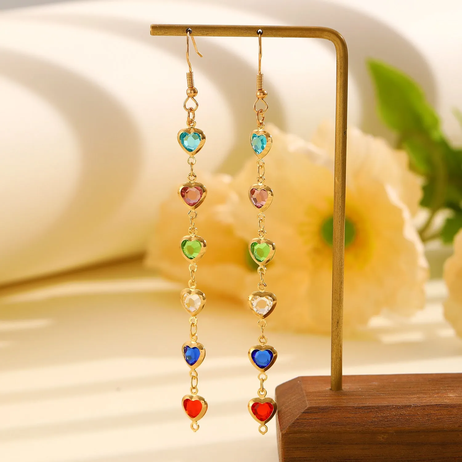 Women's colourful water drop tassel earrings in gold-tone electroplated copper on a plain background