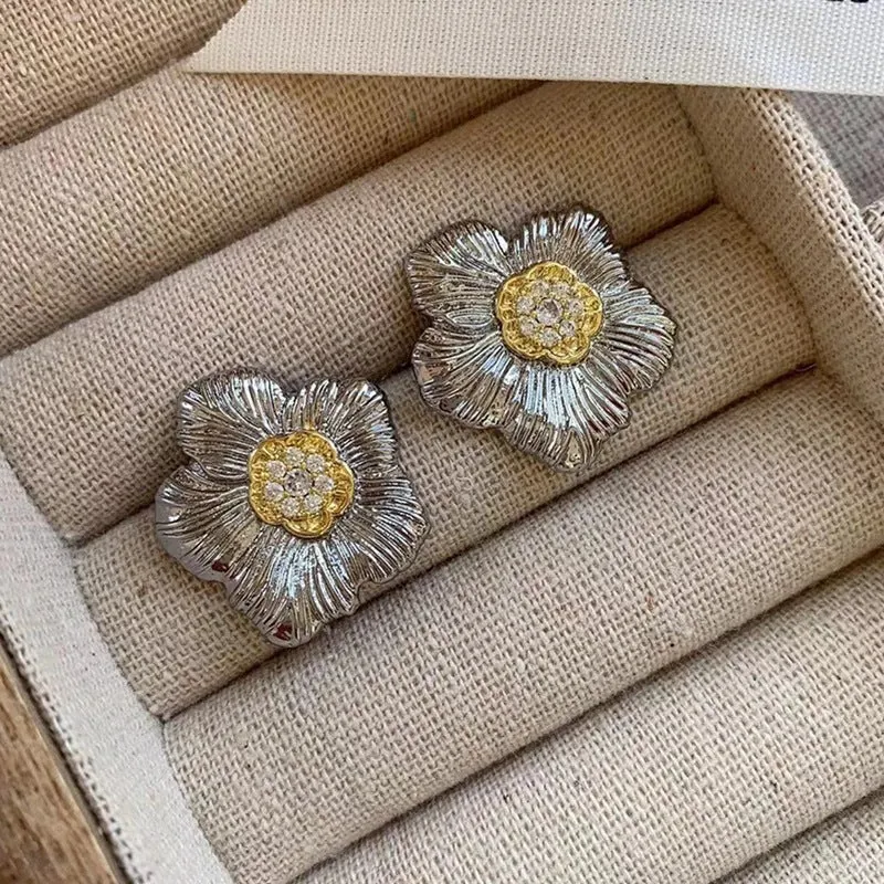 Close-up of retro textured gardenia stud earrings in two-tone copper with floral petal detail.