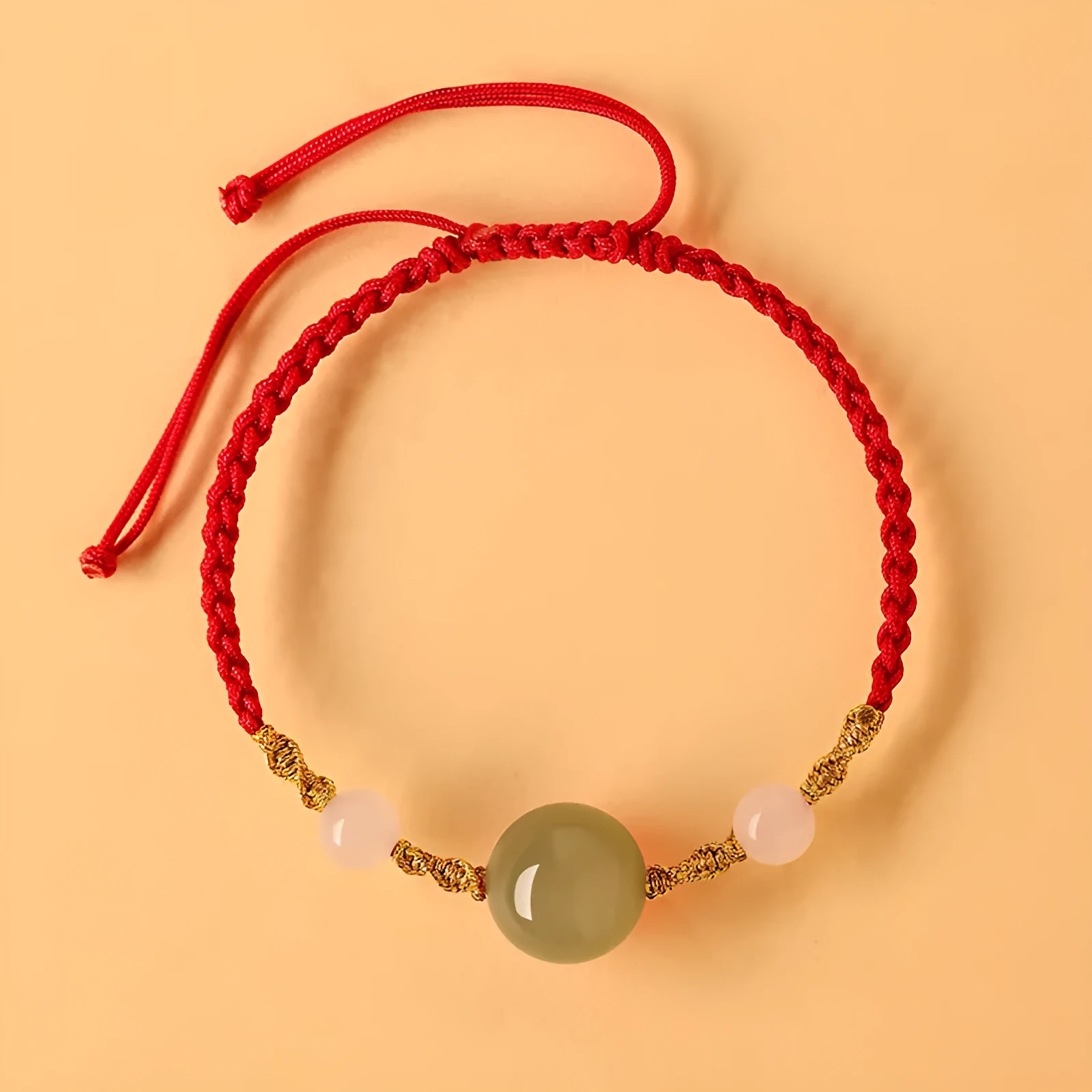 Hand-woven red rope bracelet with Hetian jade beads and intricate charm detailing.
