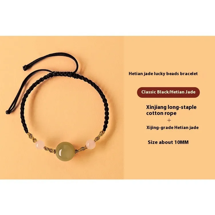 Hand-woven red rope bracelet with Hetian jade beads and intricate charm detailing.