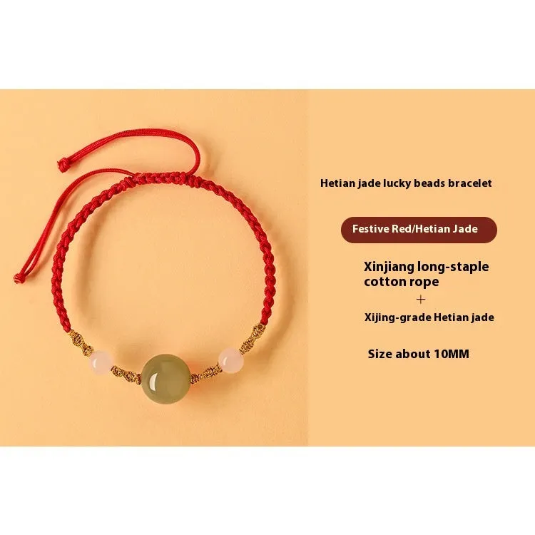 Hand-woven red rope bracelet with Hetian jade beads and intricate charm detailing.