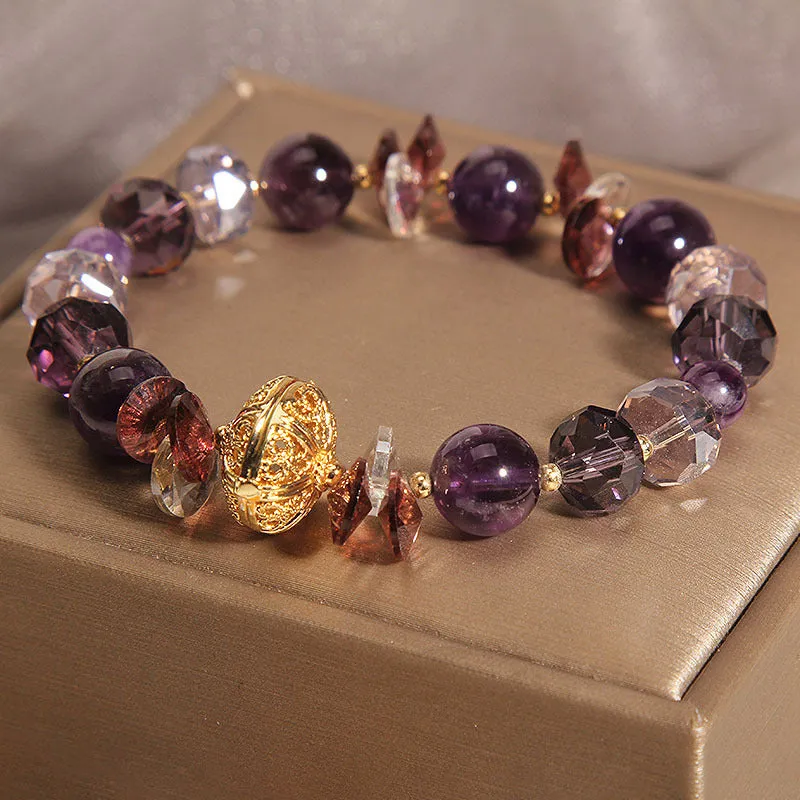 Purple crystal bracelet with pumpkin beads and a wind chimes charm on wrist.