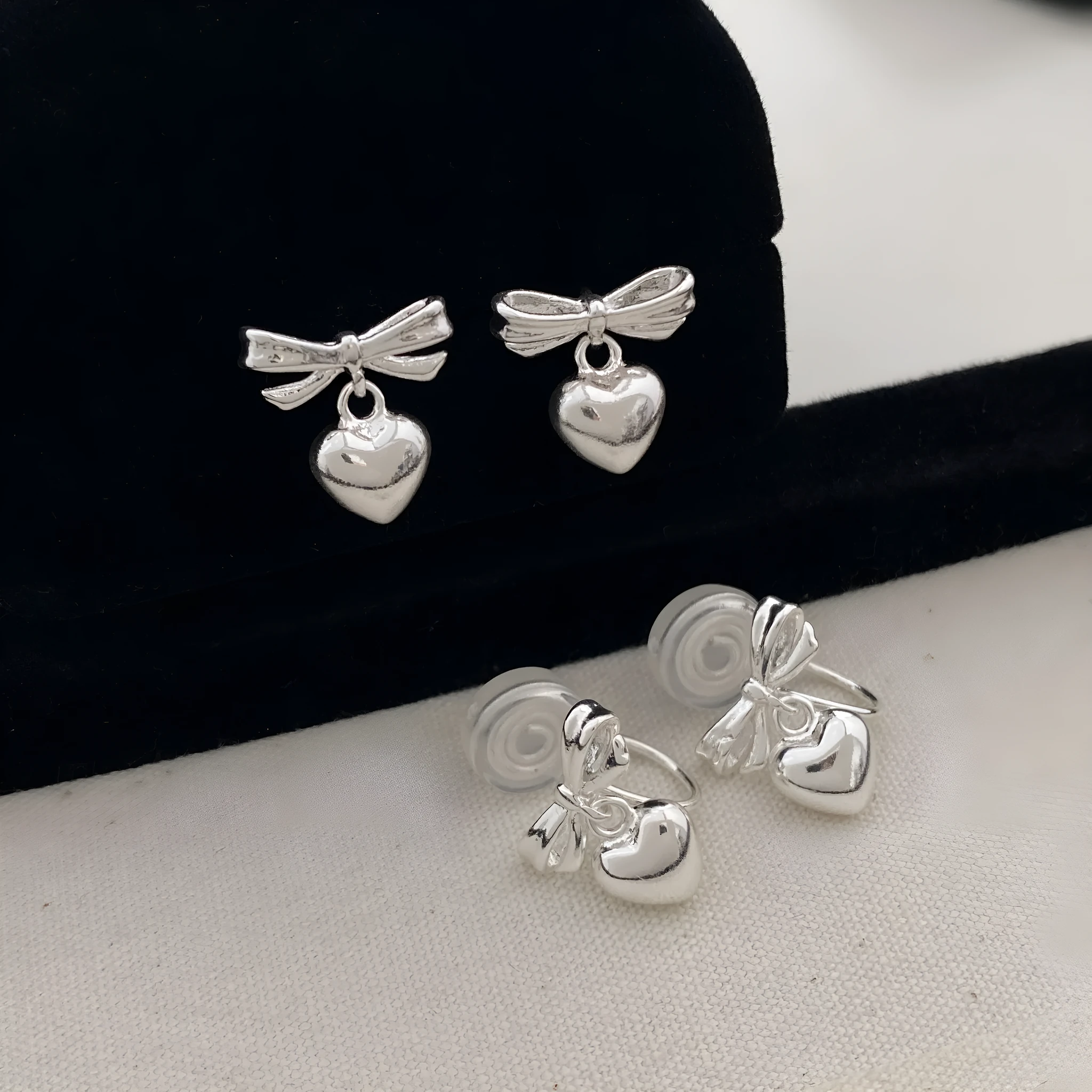 Thick silver-plated copper earrings with heart and bow design, light luxury style for women