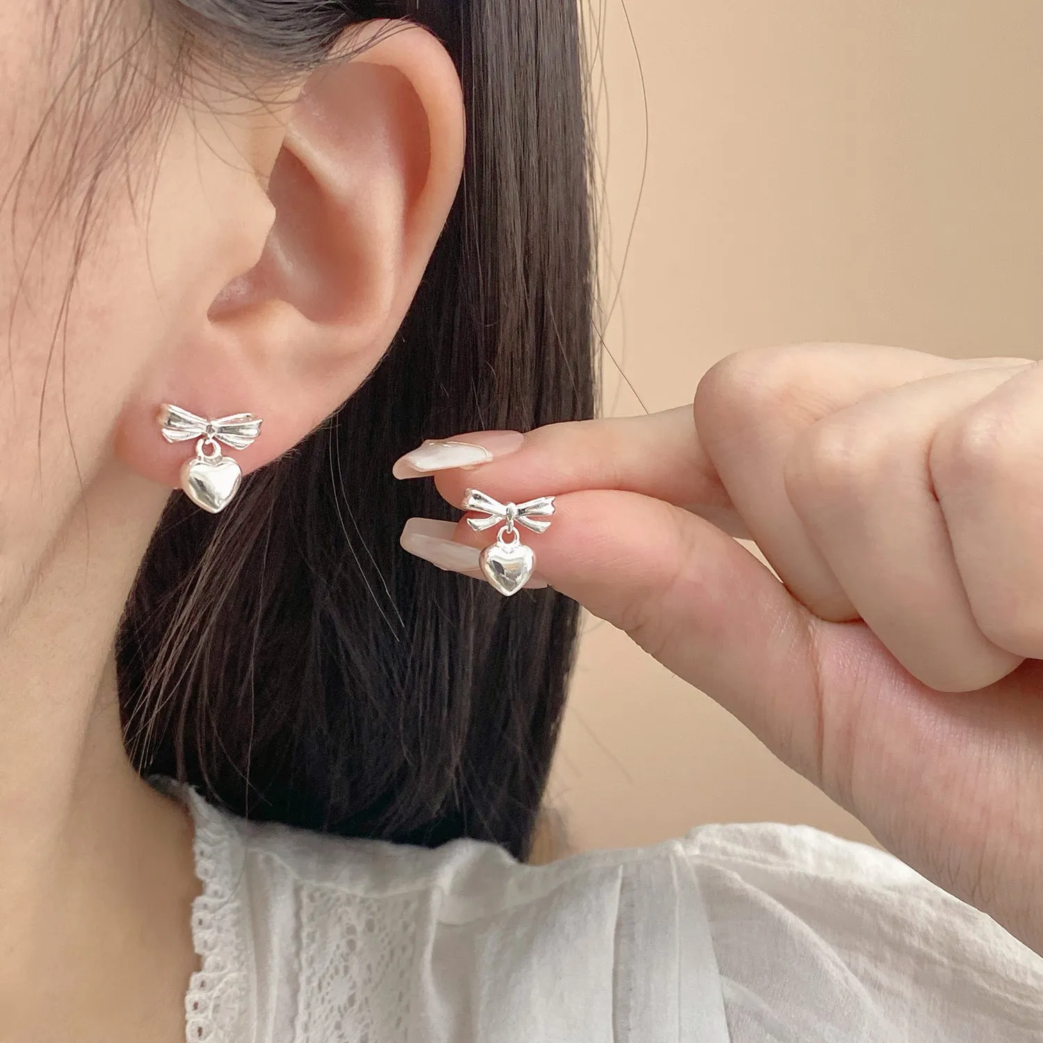Thick silver-plated copper earrings with heart and bow design, light luxury style for women
