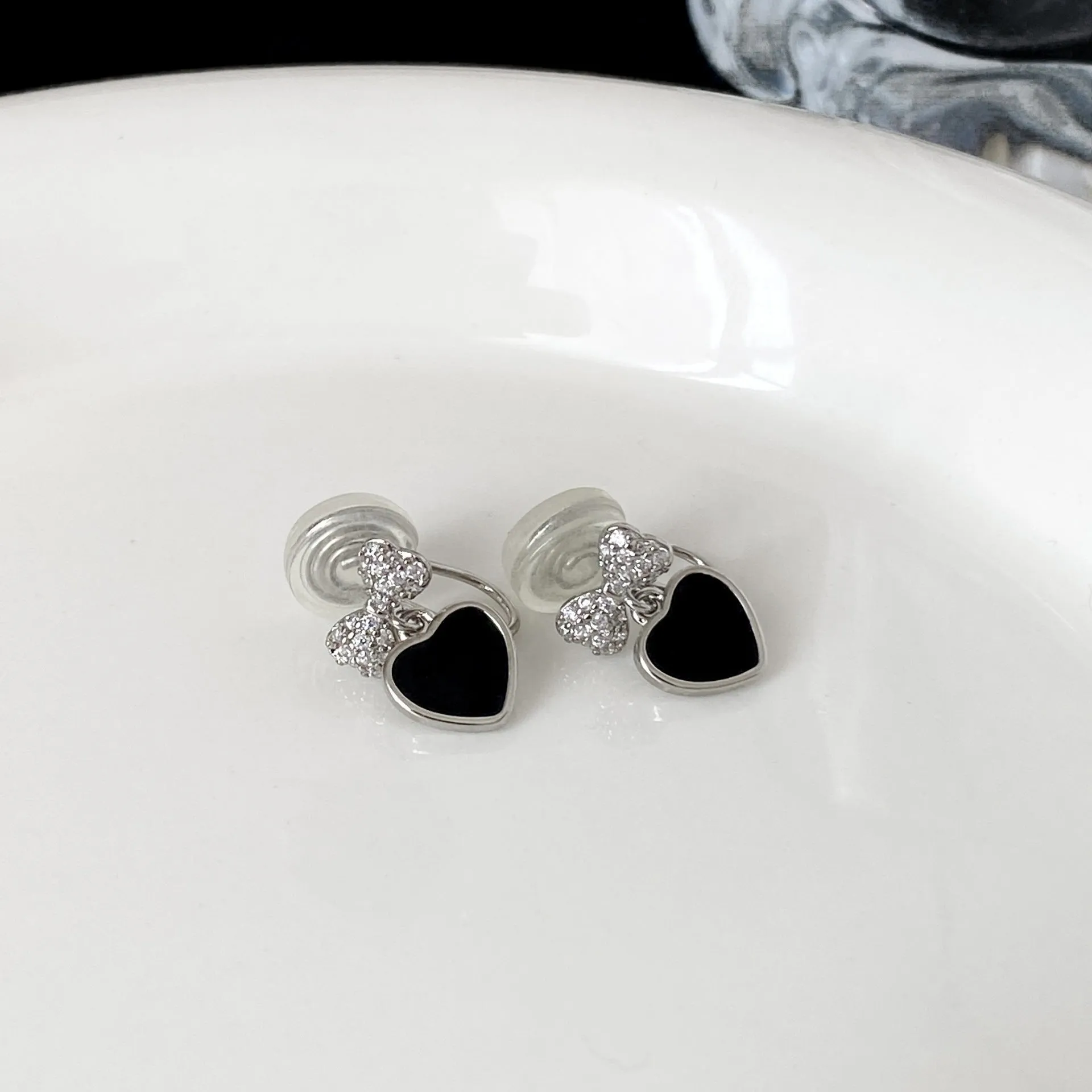 Pair of women's copper earrings, one heart-shaped and one bow-shaped, with micro-set zircon stones, ear clip and ear stud options