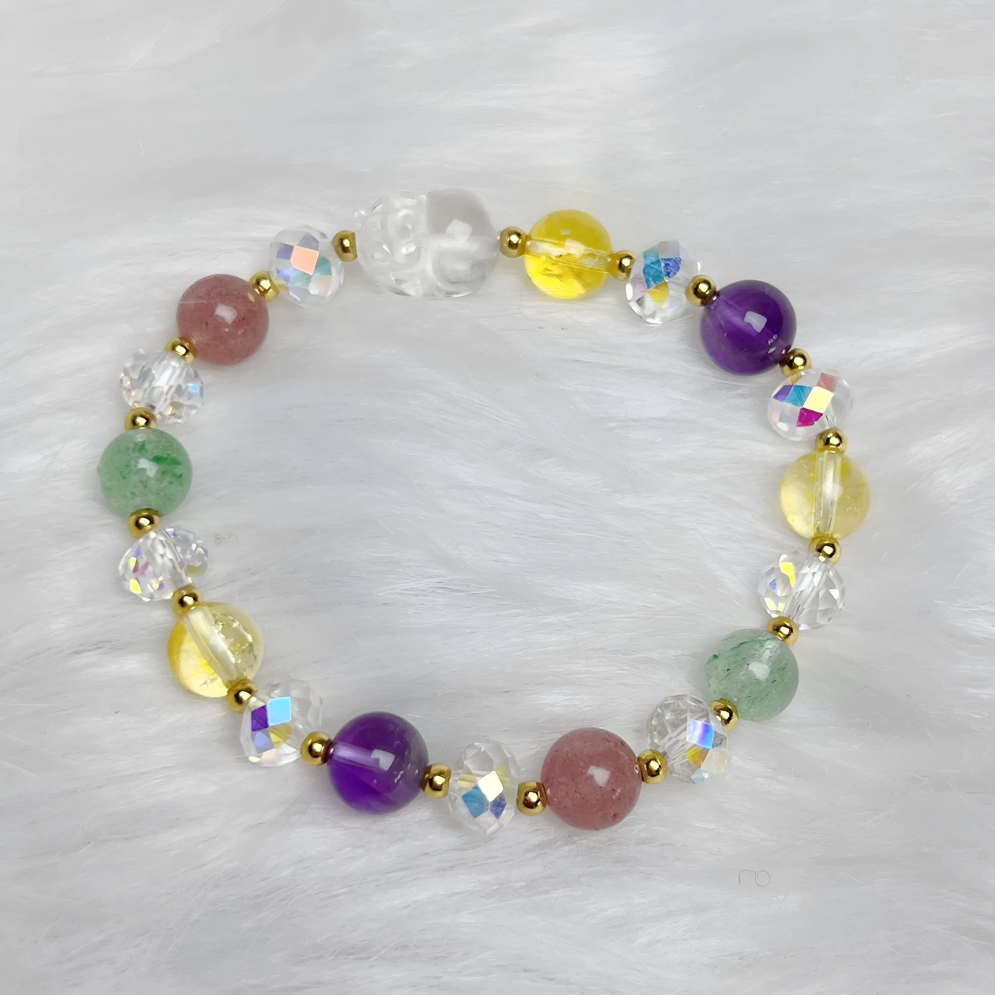 Close-up of a women's crystal bracelet with a detailed nine-tailed fox charm and colour faceted stones.