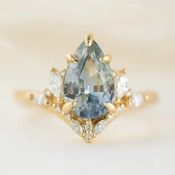Gold alloy floral ring with aquamarine crystal centre on white background