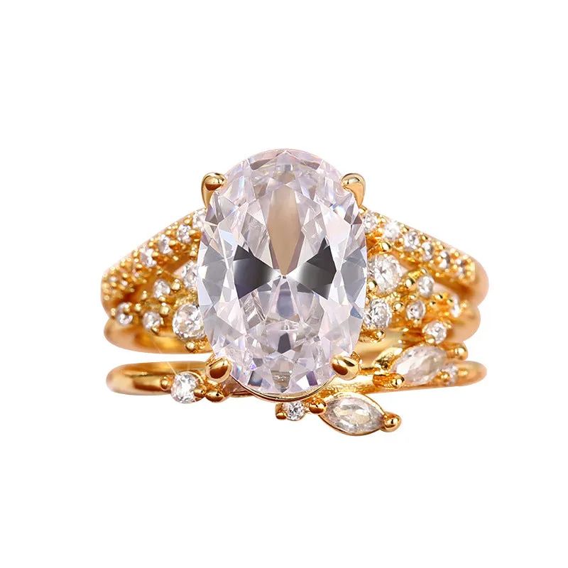 Copper zircon ring set with goose egg-shaped cut in Q681 gold on hand, three rings with flower and geometry shapes