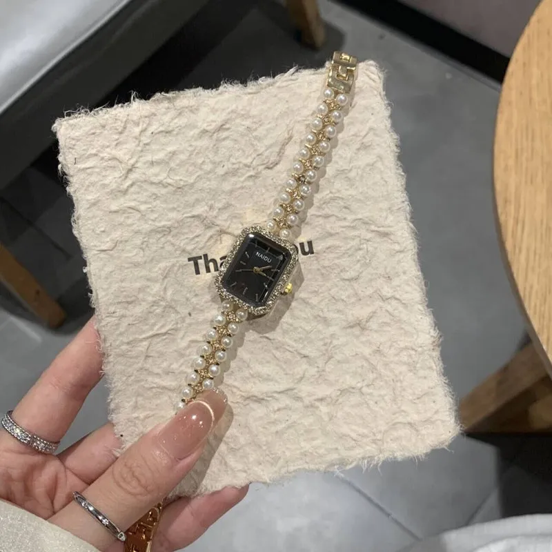 Women's fashion pearl bracelet watch with 30mm round dial, alloy strap, and quartz movement on white background