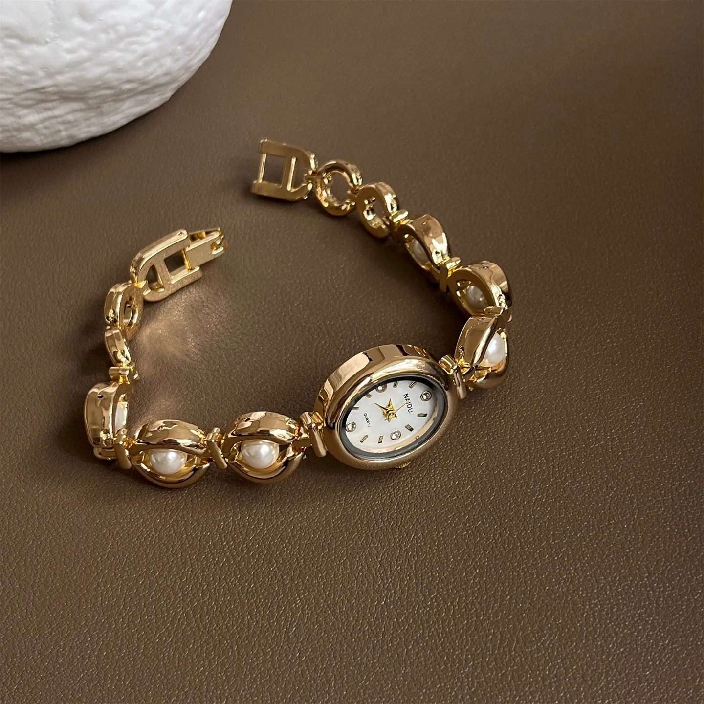 Women's quartz fashion bracelet watch with alloy case and pointer display, gold strap with white surface