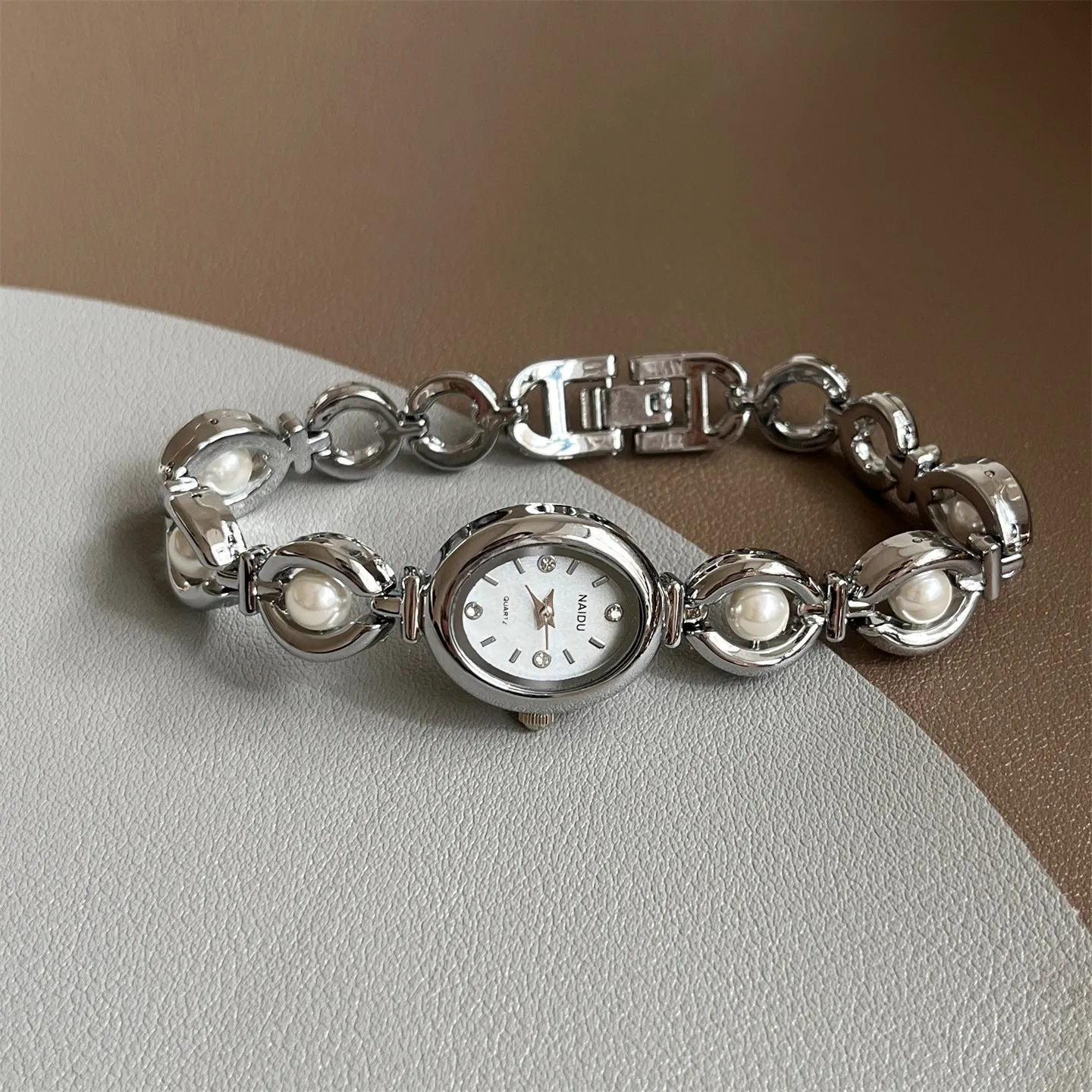 Women's quartz fashion bracelet watch with alloy case and pointer display, gold strap with white surface