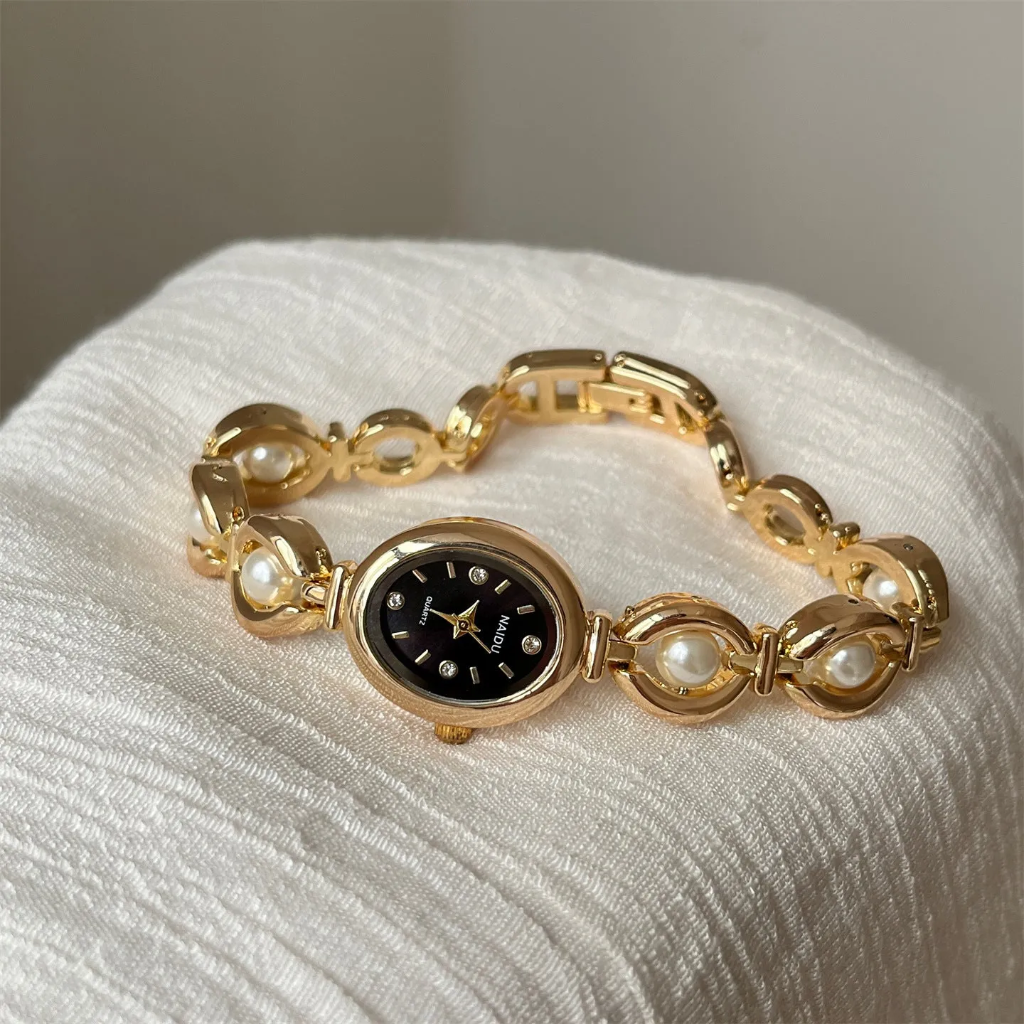 Women's quartz fashion bracelet watch with alloy case and pointer display, gold strap with white surface