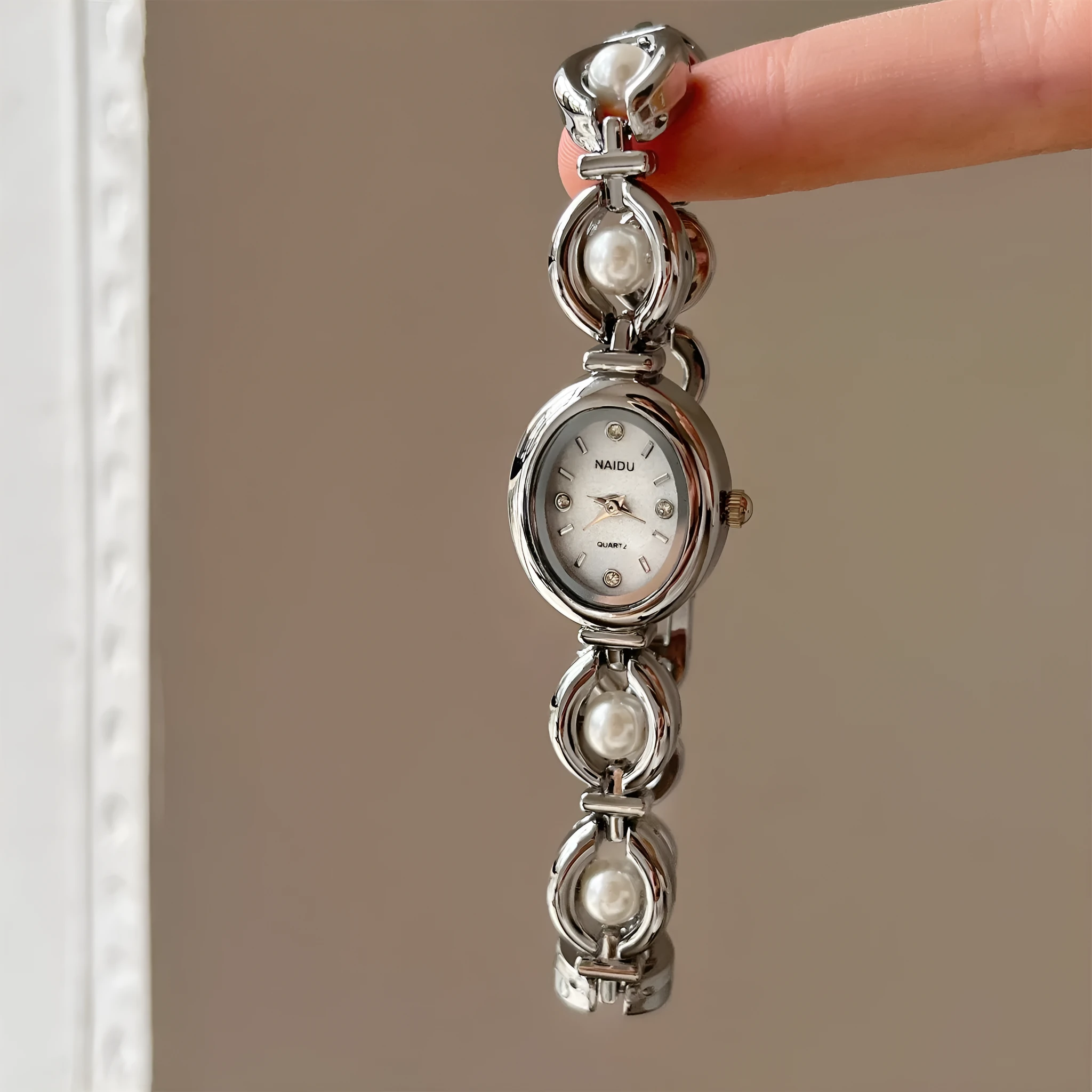 Women's quartz fashion bracelet watch with alloy case and pointer display, gold strap with white surface