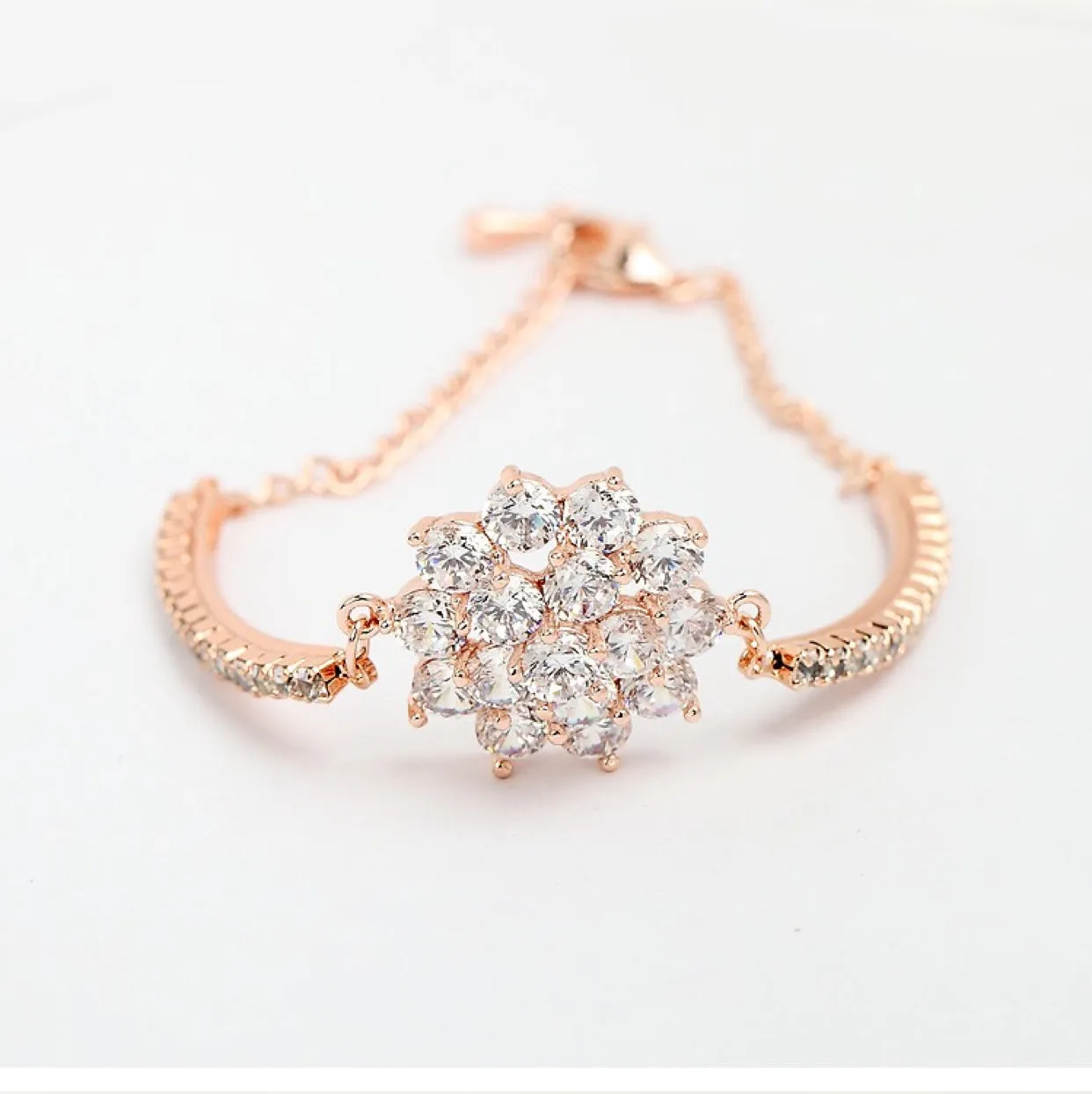 Rose gold cubic zirconia bracelet with cross crown Roman numeral motifs on alloy setting
