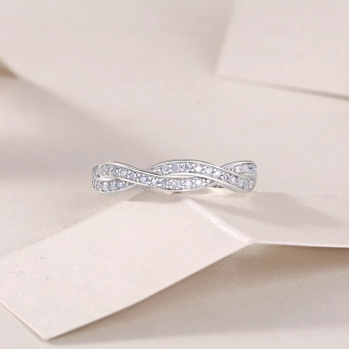 Moissanite wedding ring set in S925 silver with platinum plating on a white background