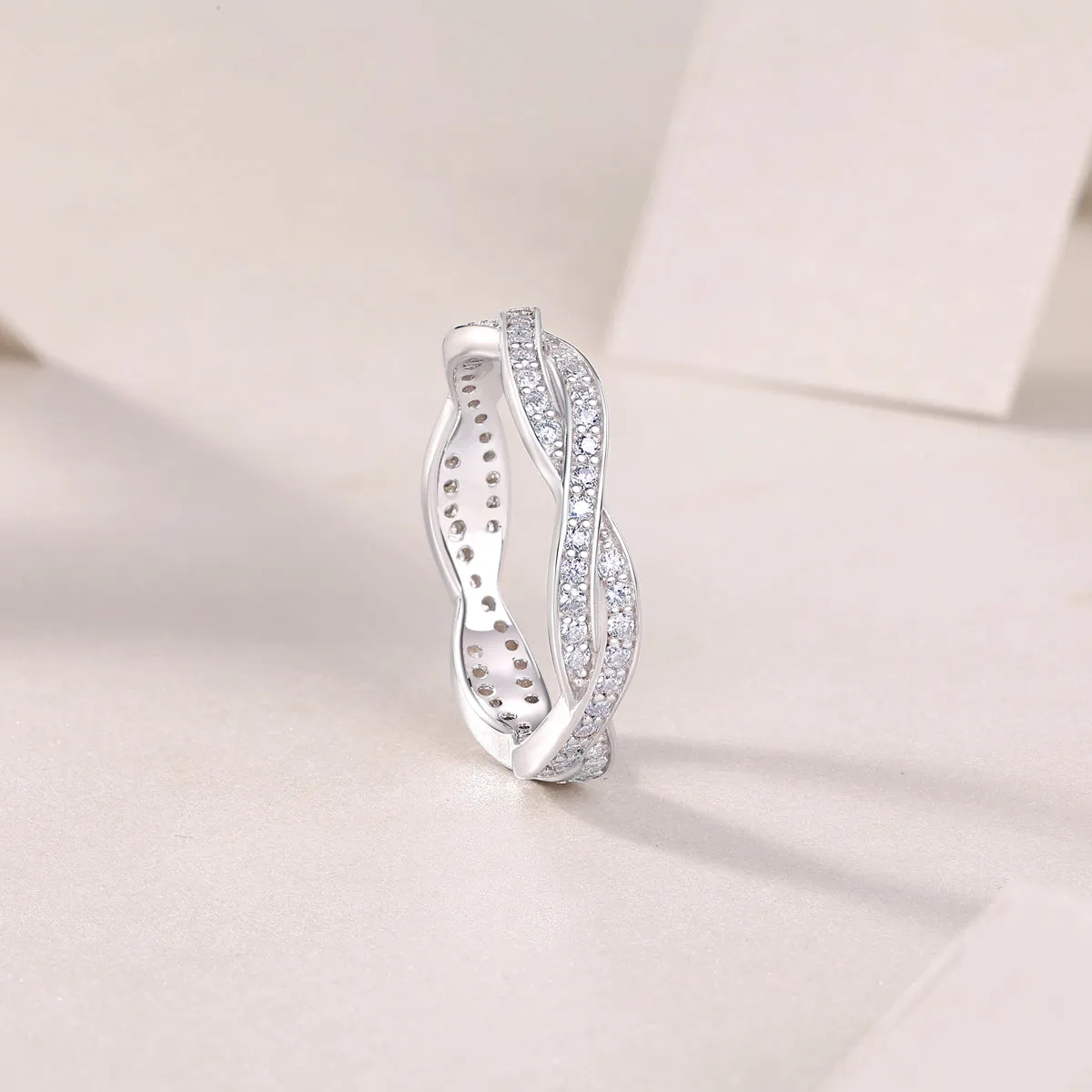 Moissanite wedding ring set in S925 silver with platinum plating on a white background