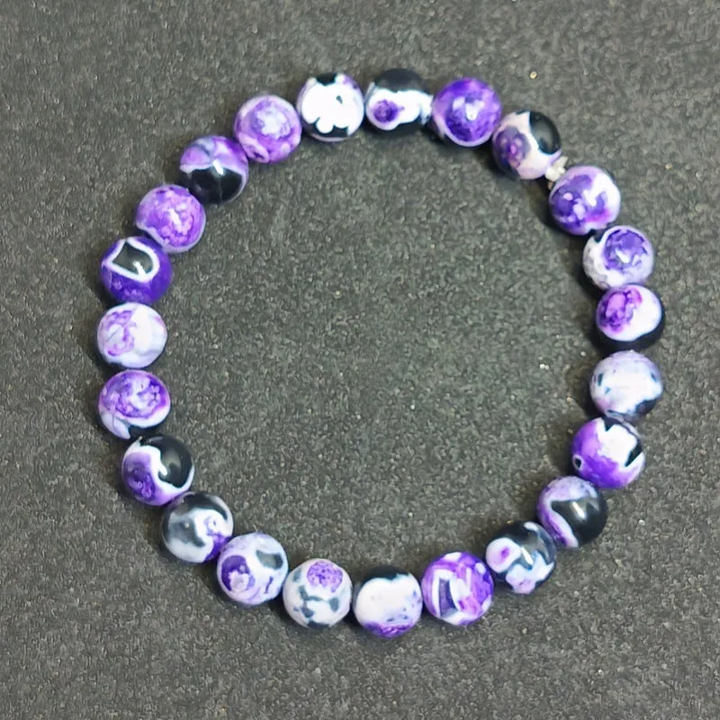 Close-up of a ladies bohemian bracelet with 8mm round glass beads in natural agate colours.