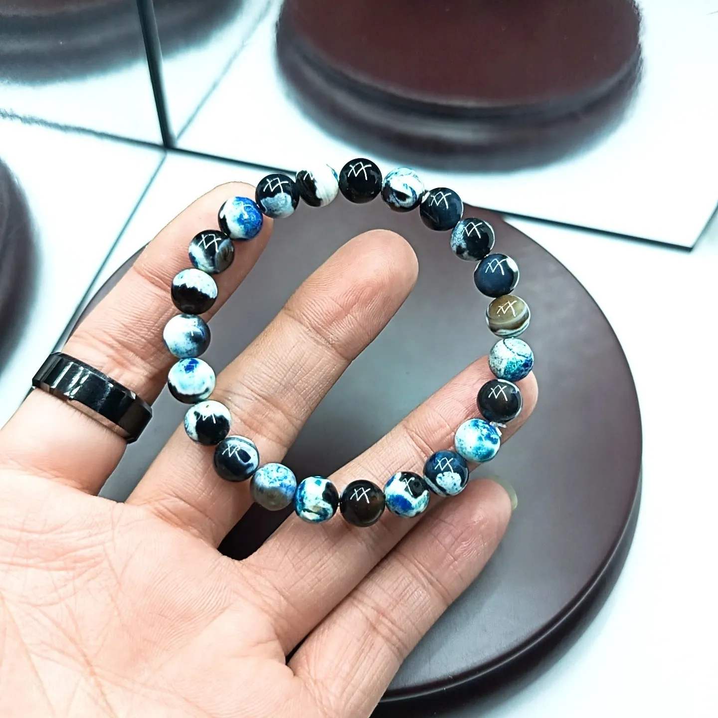 Close-up of a ladies bohemian bracelet with 8mm round glass beads in natural agate colours.