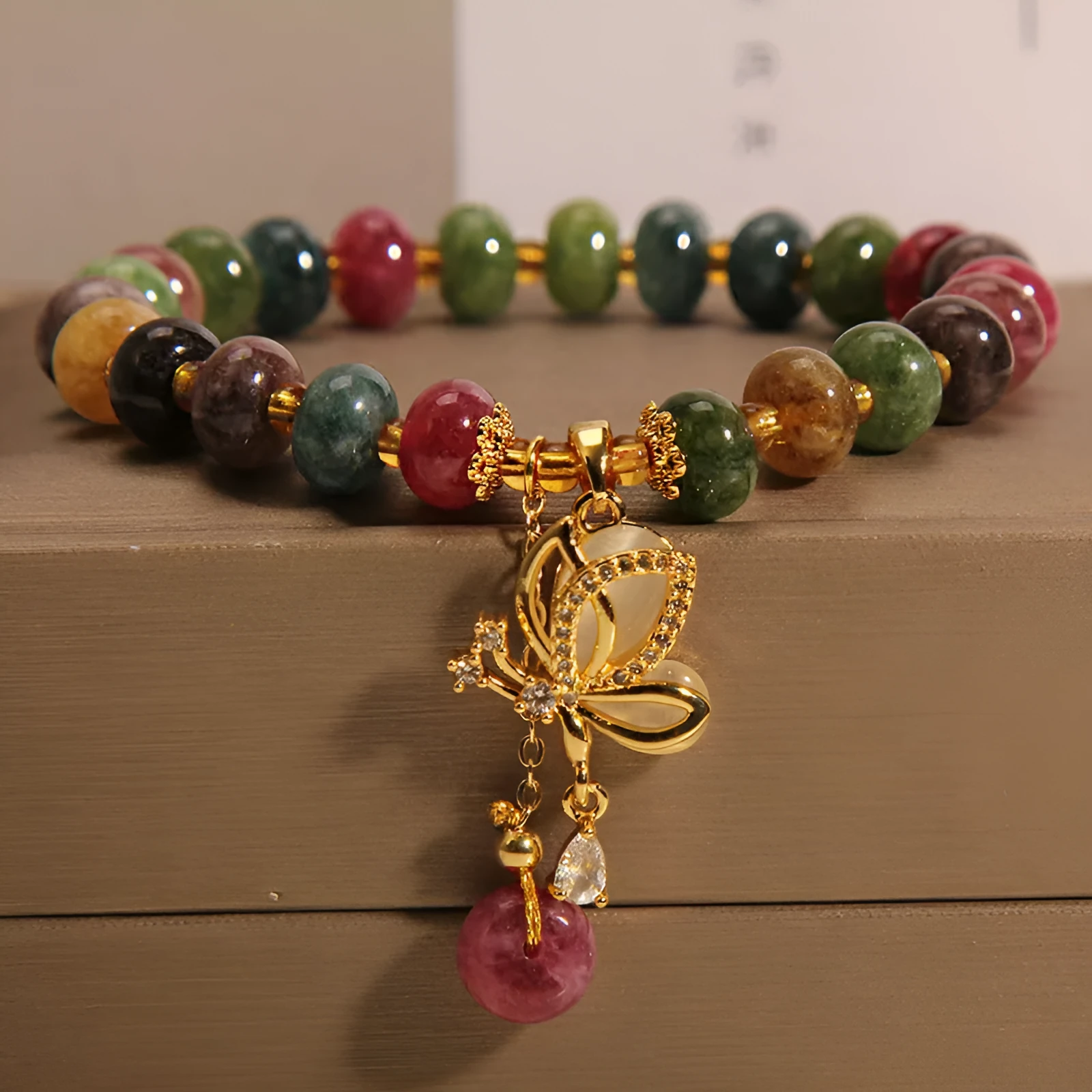 Colourful women's bracelet with butterfly charm and bead accents on alloy band