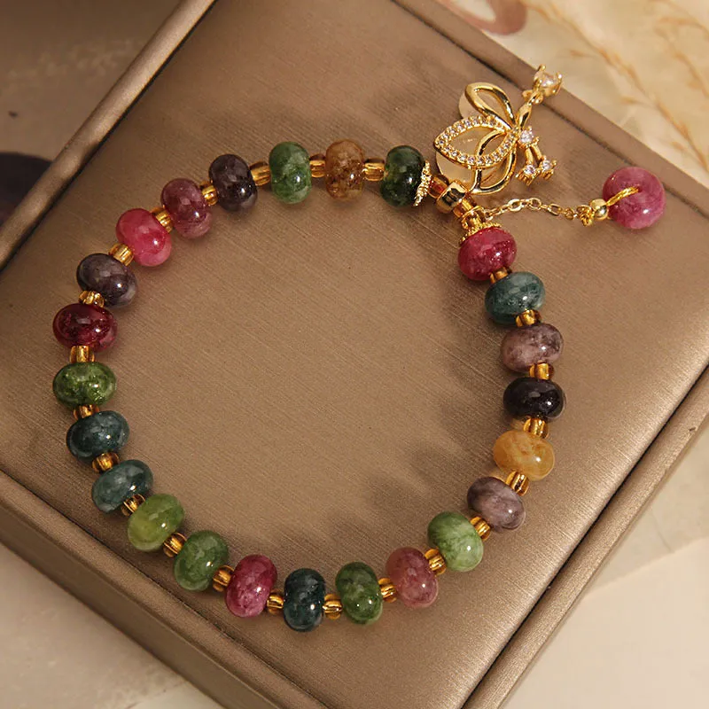Colourful women's bracelet with butterfly charm and bead accents on alloy band