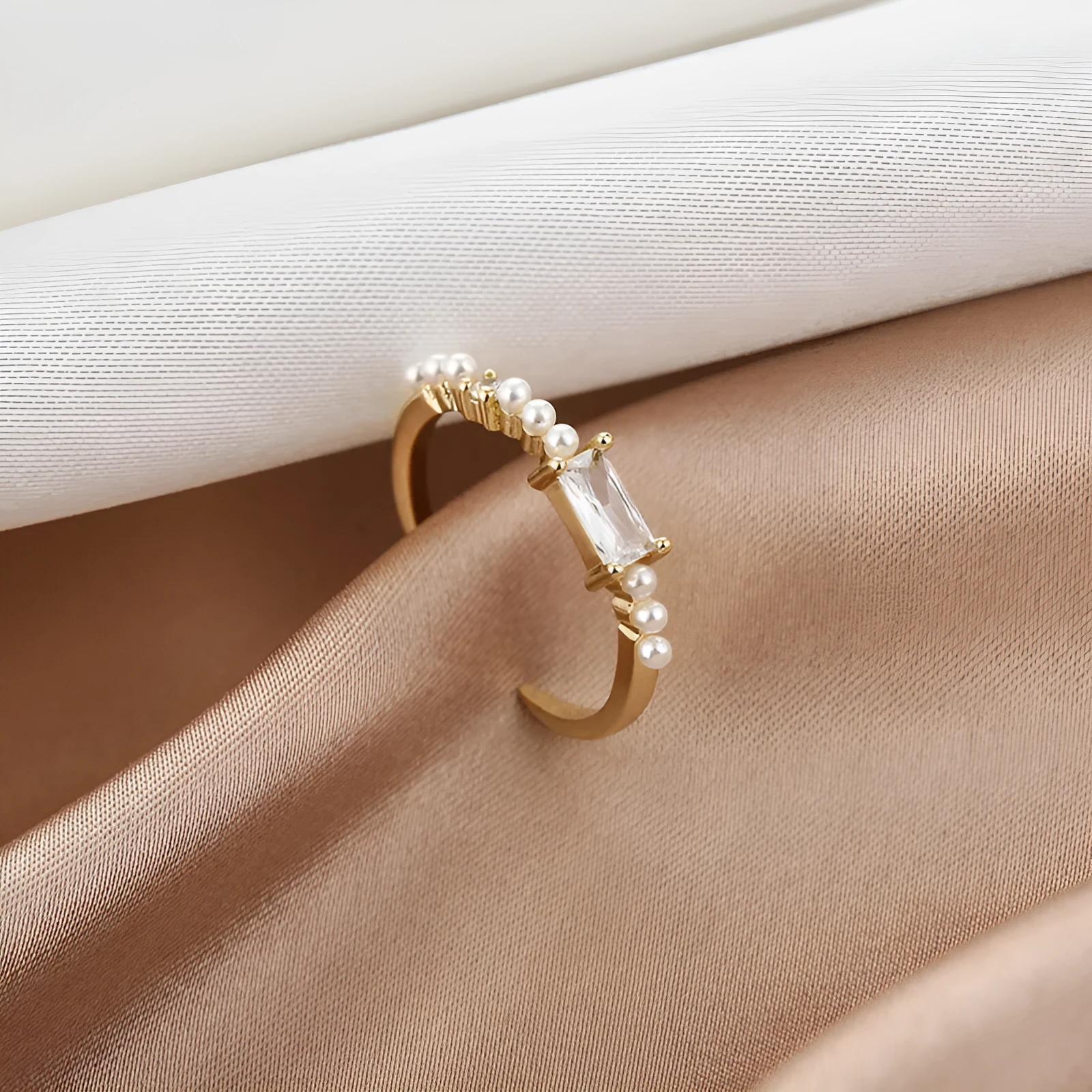 Gold alloy ring with square artificial gemstone inlay and diamond-cut surface, adjustable opening, on a white background