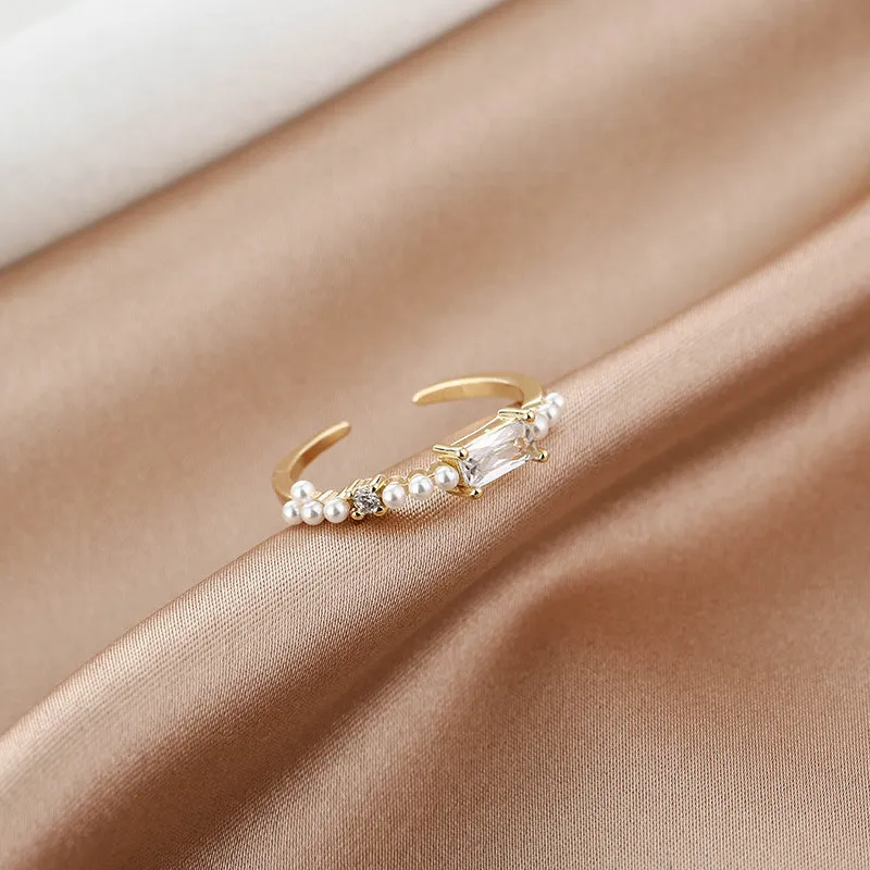 Gold alloy ring with square artificial gemstone inlay and diamond-cut surface, adjustable opening, on a white background