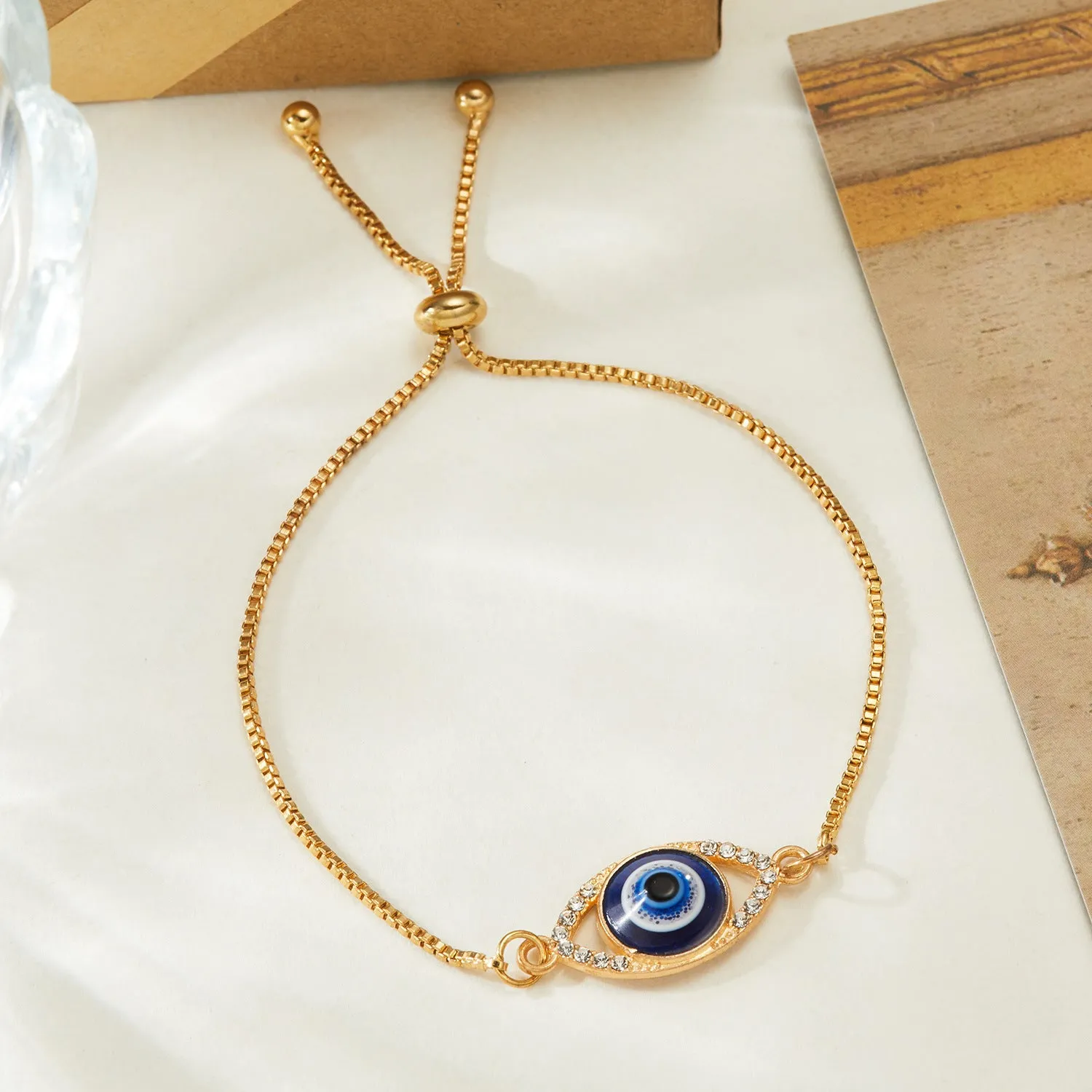 Hollow devil eye point diamond adjustable chain bracelet in stainless steel, close up of pendant